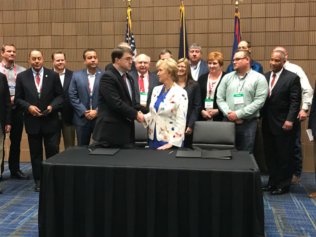 Photo of Linda shaking someone's hand.