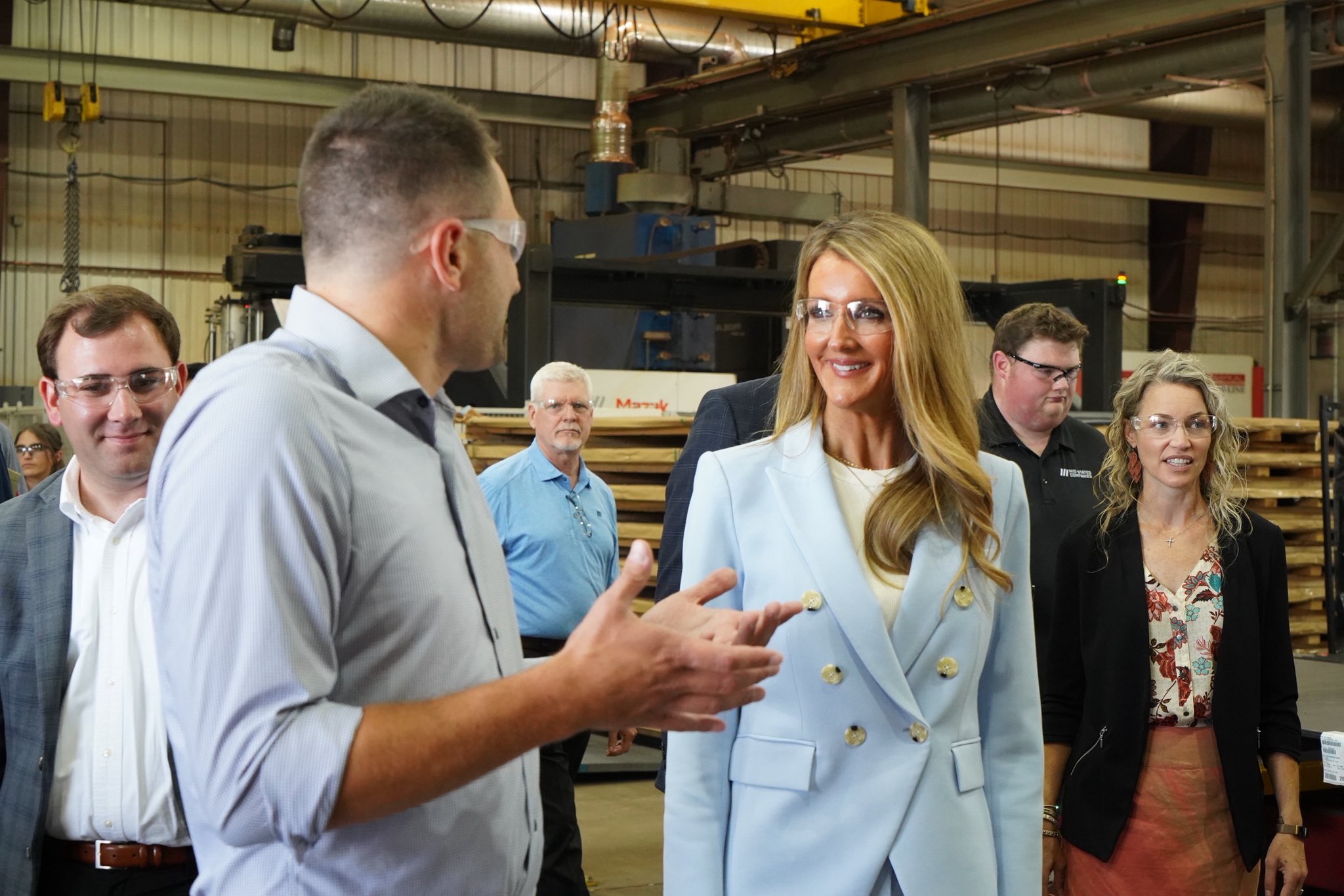 Administrator Loeffler, in protective goggles, speaks to a small business owners and SBA staff