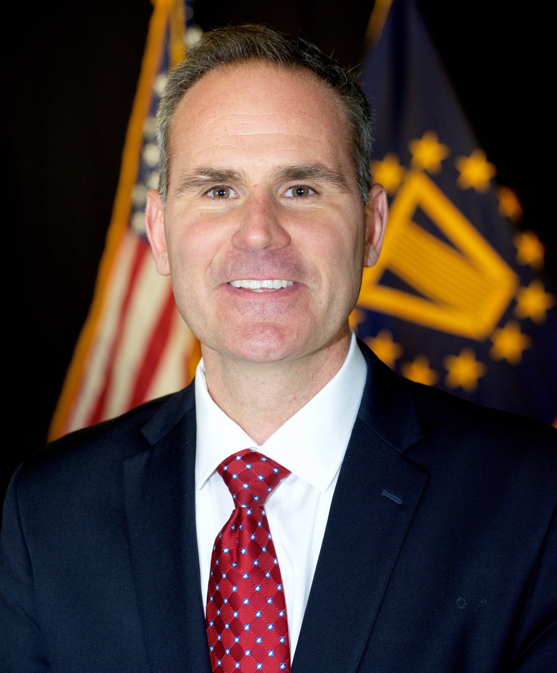 Chris Pilkerton professional headshot with American flag in the background