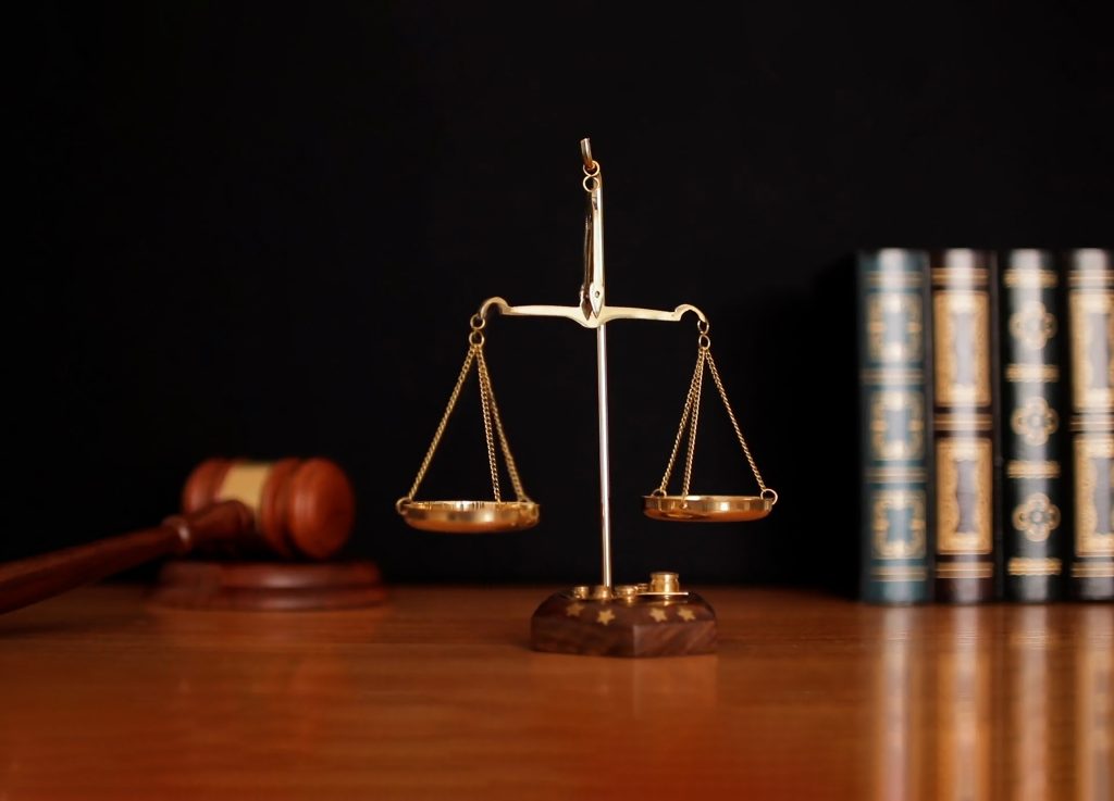 Justice scales with a gavel and books in the background