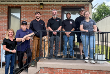 A group of people and a dog outside of a building.