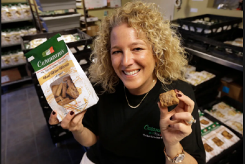 Kristen Catanzaro of Catanzaro Food Products Inc holds up a cookies and a package of cookies.
