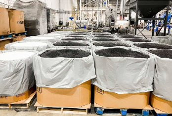 Lined-up cardboard boxes on pallets in a manufacturing warehouse.