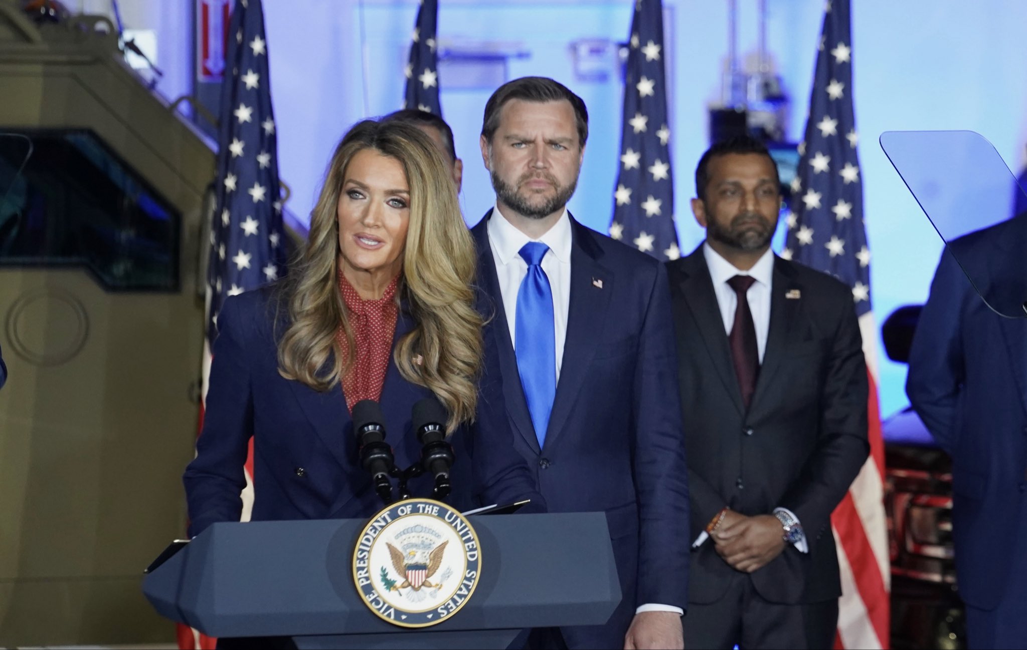 Administrator Loeffler at a podium with the Vice President and FBI director in the background